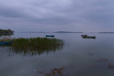 Güzel bir gün batımı manzarası Uluabat gölü ve Golyazi Köyü, Ulubat Gölü, Bursa Türkiye 'den gelen bazı balıkçı tekneleri...