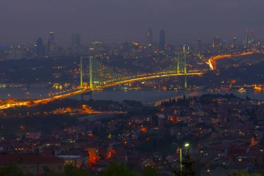 Güneş doğarken İstanbul Boğaz Köprüsü 'nün fotoğrafı. Asya ve Avrupa olmak üzere iki farklı kıtayı birleştirir. Burada görünen kıta Asya 'dır. Koyu mavi gökyüzü ve detaylı binalar görünür.. 