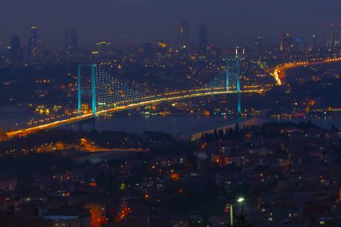 Güneş doğarken İstanbul Boğaz Köprüsü 'nün fotoğrafı. Asya ve Avrupa olmak üzere iki farklı kıtayı birleştirir. Burada görünen kıta Asya 'dır. Koyu mavi gökyüzü ve detaylı binalar görünür.. 