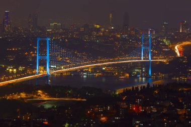 Güneş doğarken İstanbul Boğaz Köprüsü 'nün fotoğrafı. Asya ve Avrupa olmak üzere iki farklı kıtayı birleştirir. Burada görünen kıta Asya 'dır. Koyu mavi gökyüzü ve detaylı binalar görünür.. 