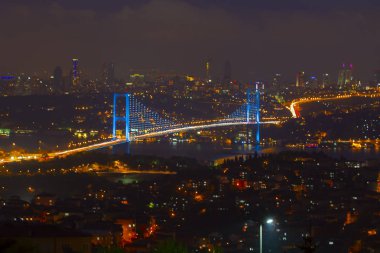 Güneş doğarken İstanbul Boğaz Köprüsü 'nün fotoğrafı. Asya ve Avrupa olmak üzere iki farklı kıtayı birleştirir. Burada görünen kıta Asya 'dır. Koyu mavi gökyüzü ve detaylı binalar görünür.. 