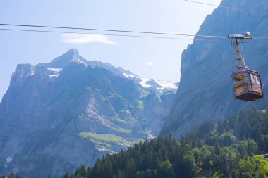 Şaşırtıcı İsviçre dağlık arazisi, yeşil tarlalarda ahşap kiremitler ve arka planda karlı zirveler bulunan yüksek dağlar, Grindelwald, Bernese Oberland, İsviçre, Avrupa