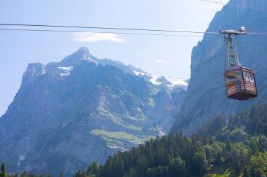 Şaşırtıcı İsviçre dağlık arazisi, yeşil tarlalarda ahşap kiremitler ve arka planda karlı zirveler bulunan yüksek dağlar, Grindelwald, Bernese Oberland, İsviçre, Avrupa