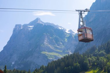 Şaşırtıcı İsviçre dağlık arazisi, yeşil tarlalarda ahşap kiremitler ve arka planda karlı zirveler bulunan yüksek dağlar, Grindelwald, Bernese Oberland, İsviçre, Avrupa