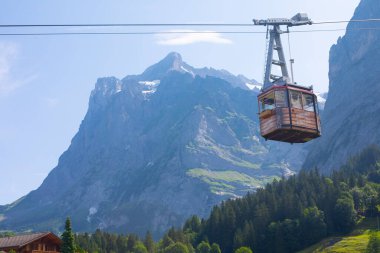 Şaşırtıcı İsviçre dağlık arazisi, yeşil tarlalarda ahşap kiremitler ve arka planda karlı zirveler bulunan yüksek dağlar, Grindelwald, Bernese Oberland, İsviçre, Avrupa