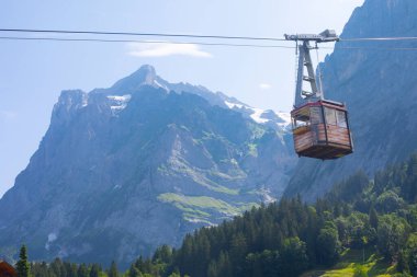 Şaşırtıcı İsviçre dağlık arazisi, yeşil tarlalarda ahşap kiremitler ve arka planda karlı zirveler bulunan yüksek dağlar, Grindelwald, Bernese Oberland, İsviçre, Avrupa
