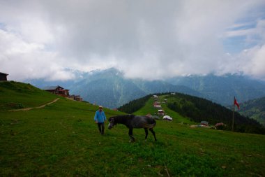 Türkiye 'nin Pokut Masa Diyarı bölgesindeki tepedeki kır evleri mavi gökyüzü ve bulutlu.