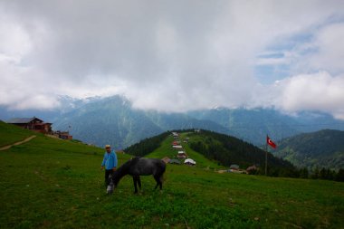 Türkiye 'nin Pokut Masa Diyarı bölgesindeki tepedeki kır evleri mavi gökyüzü ve bulutlu.