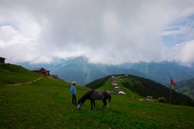 Türkiye 'nin Pokut Masa Diyarı bölgesindeki tepedeki kır evleri mavi gökyüzü ve bulutlu.