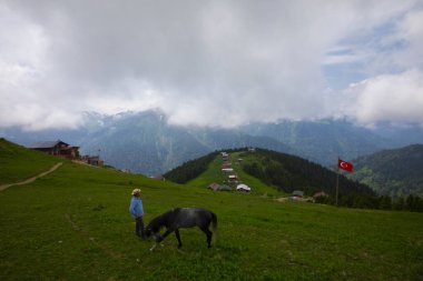 Türkiye 'nin Pokut Masa Diyarı bölgesindeki tepedeki kır evleri mavi gökyüzü ve bulutlu.