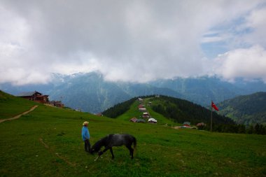 Türkiye 'nin Pokut Masa Diyarı bölgesindeki tepedeki kır evleri mavi gökyüzü ve bulutlu.
