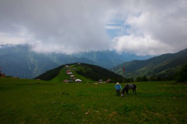 Türkiye 'nin Pokut Masa Diyarı bölgesindeki tepedeki kır evleri mavi gökyüzü ve bulutlu.
