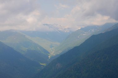 Dağlık arazide geleneksel ahşap evler. Manzara fotoğrafı Türkiye 'nin Pokut, Rize, Karadeniz / Karadeniz bölgesinde çekildi. Pokut, Rize 'nin en yüksek rakımlı tatil beldelerinden biridir..