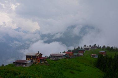 Dağlık arazide geleneksel ahşap evler. Manzara fotoğrafı Türkiye 'nin Pokut, Rize, Karadeniz / Karadeniz bölgesinde çekildi. Pokut, Rize 'nin en yüksek rakımlı tatil beldelerinden biridir..