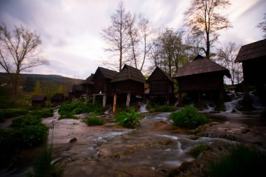 Bosna-Hersek 'in Jajce kentinde şelalelerin üzerine inşa edilmiş küçük ahşap fabrikaları.
