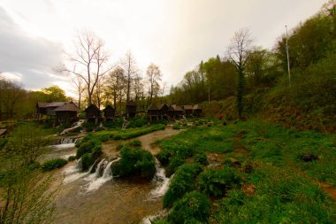 Bosna-Hersek 'in Jajce kentinde şelalelerin üzerine inşa edilmiş küçük ahşap fabrikaları.