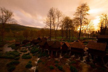 Bosna-Hersek 'in Jajce kentinde şelalelerin üzerine inşa edilmiş küçük ahşap fabrikaları.