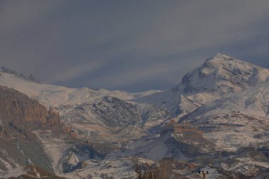 Karlı dağlar ve Dogubayazit üzerindeki manzaralı Ishak Paşa sarayı manzarası.