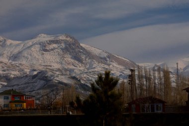 Karlı dağlar ve Dogubayazit üzerindeki manzaralı Ishak Paşa sarayı manzarası.