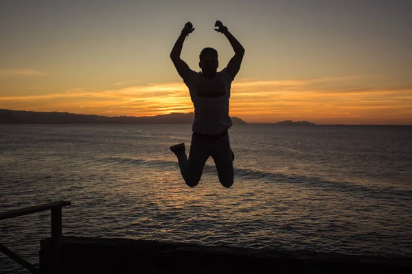 Model jumping with amazing back lighting sunset behind