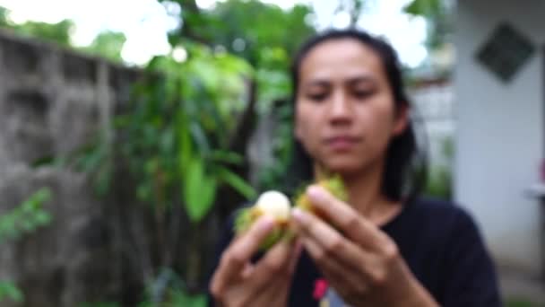 ランブータン果実を開く女性スローモーションします — ストック動画