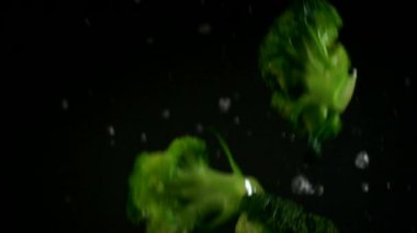 Brokoli siyah arka plan üzerinde yavaş hareket dökme