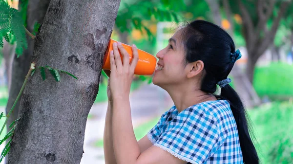 Азия женщины говорят, чтобы отправить сообщение на дерево — стоковое фото