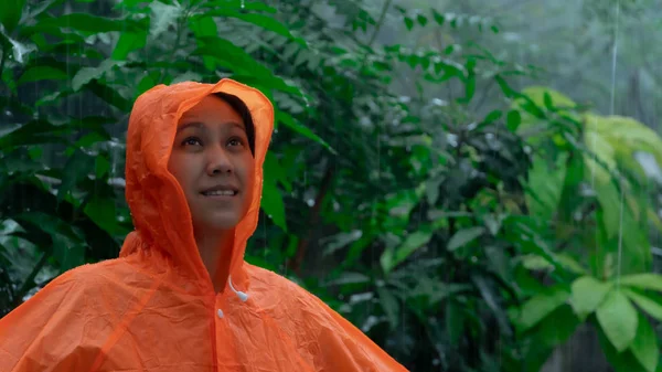 Yağmurda turuncu yağmurluk giyen kadın — Stok fotoğraf