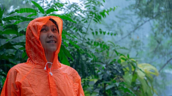 Mujer con impermeable naranja en la lluvia —  Fotos de Stock