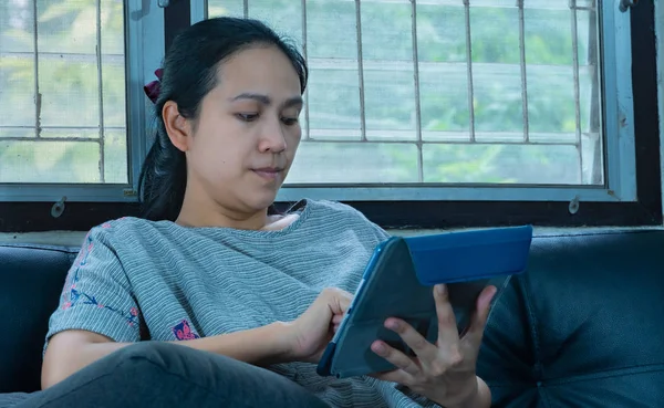 Güzel kadın evde koltukta oturan tablet kullanma — Stok fotoğraf