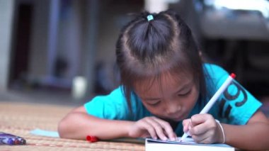 Kız mutlu onları göstermeden önce anne ve babasını çizmek için sihirli renk kullanır