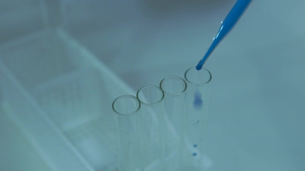 研究者は 研究室の試験管に化学物質を滴下 — ストック動画