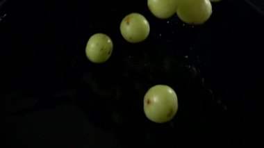 Emblica meyvesi yavaş çekimde suya dökülüyor
