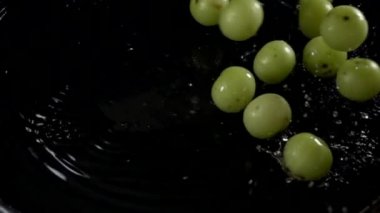 Emblica meyvesi yavaş çekimde suya dökülüyor