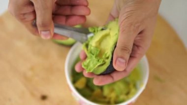 Şef mutfakta avokado meyvesi pişiriyor.