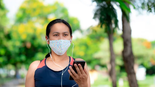 公園でマスクジョギングを着てアジアの女性の肖像画 — ストック写真