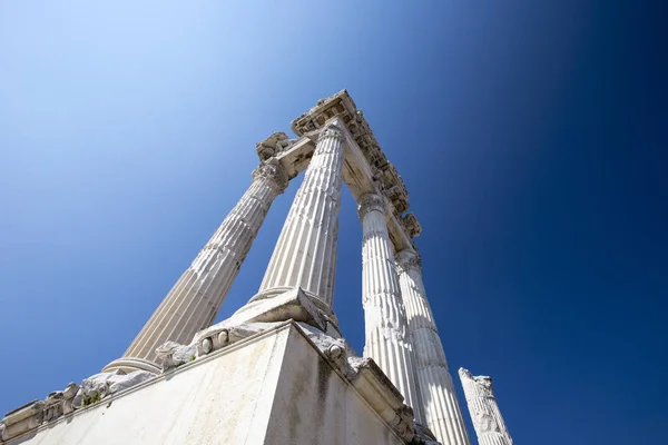 Mavi gökyüzü karşı uzun boylu sütunlarla antik bir Roma Tapınağı kalıntıları açısı yakın çekim.