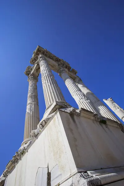 Mavi gökyüzü karşı uzun boylu sütunlarla antik bir tapınak kalıntıları köşesine yakın çekim.