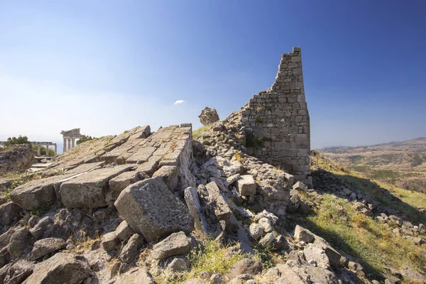 Eski bir kale ve kale kule mavi gökyüzüne karşı arka planda antik bir tapınak ile yıkıntıları Close-up.