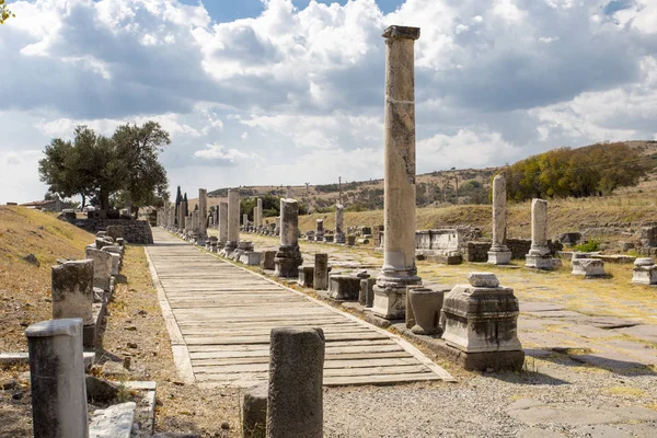 Bir antik yol sütunlarla yakın çekim yatay görünümünü yolun mavi gökyüzü bulutlu Asclepion antik şehir içinde karşı tarafında
