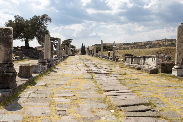 Bir antik yol sütunlarla yakın çekim yatay görünümünü yolun mavi gökyüzü bulutlu Asclepion antik şehir içinde karşı tarafında