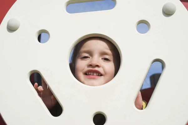 Счастливая маленькая девочка на детской площадке — стоковое фото