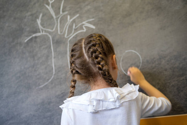 Elementary student drawing on blackboard