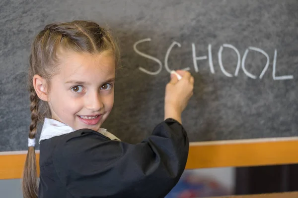 Elementary school student poserar i uniform i en klass — Stockfoto