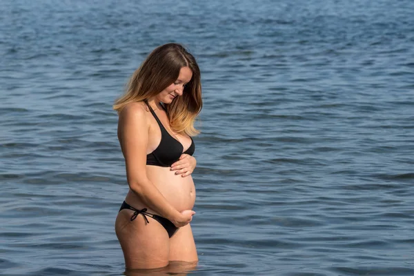 Mulher grávida de pé no mar — Fotografia de Stock