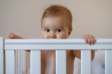 8 aylık kız bebek beşikte duruyor.