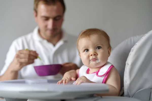 Pai Alimentando Bebê Filha Com Colher Cadeira Alta — Fotografia de Stock