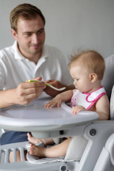 Pai Alimentando Bebê Filha Com Colher Cadeira Alta — Fotografia de Stock