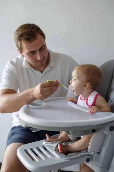 Pai Alimentando Bebê Filha Com Colher Cadeira Alta — Fotografia de Stock