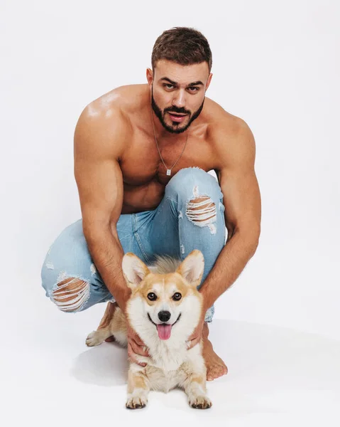 Köpek corgisiyle erkek fitness modeli